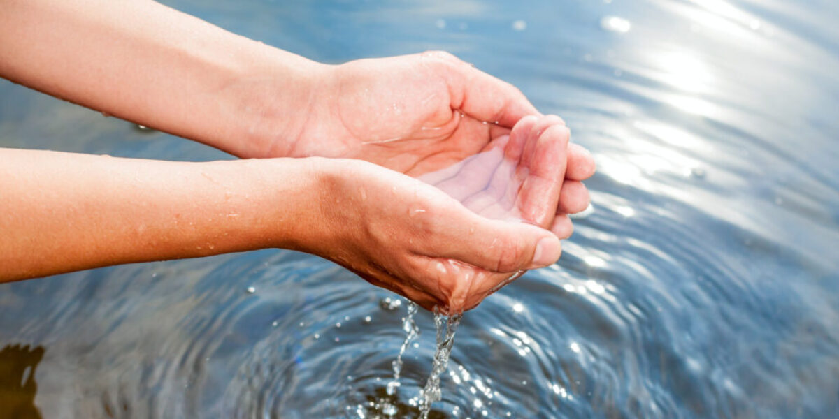 hands dipping in water