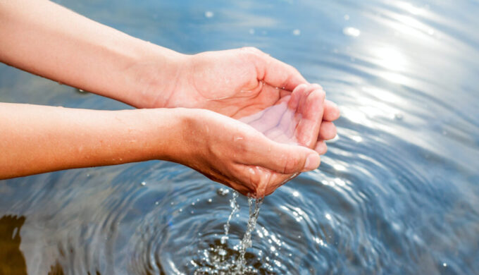 hands dipping in water